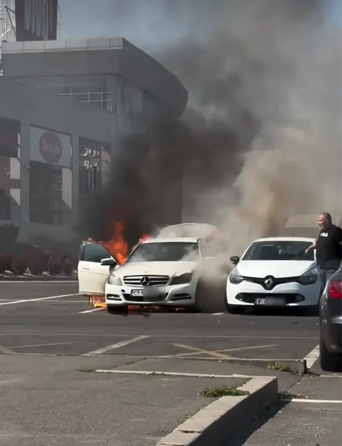 Un Mercedes a luat foc în parcarea unui centru comercial